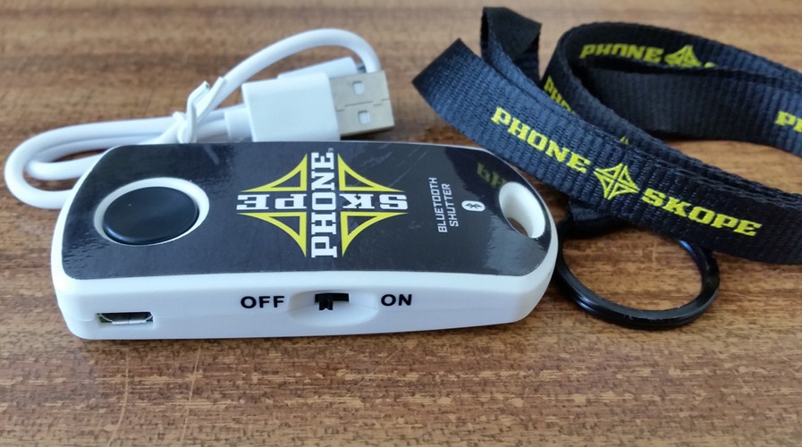 CLose-up of Phoneskope Bluetooth shutter button, USB cable and neck strap